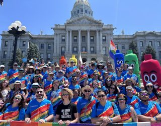 Denver Health employees stand in front of the state capitol building during the 2022 Denver LGBTQ+ Pride Parade