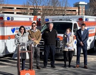 Denver Health trauma survivor Jessica Barclay addresses the media during a press conference, announcing the acquisition of 10 new ambulances for the Denver Health Paramedic Division fleet. Seen alongside her are Denver Mayor Mike Johnston, Denver Health Paramedic Division Chief Gary Bryskiewicz, Denver Health CEO Donna Lynne, and Colin Barclay, Jessica’s husband and Denver Health Foundation board member. The Barclays, with The Anschutz Foundation and other Denver Health Foundation donors, played a pivotal role in funding these new vehicles.
